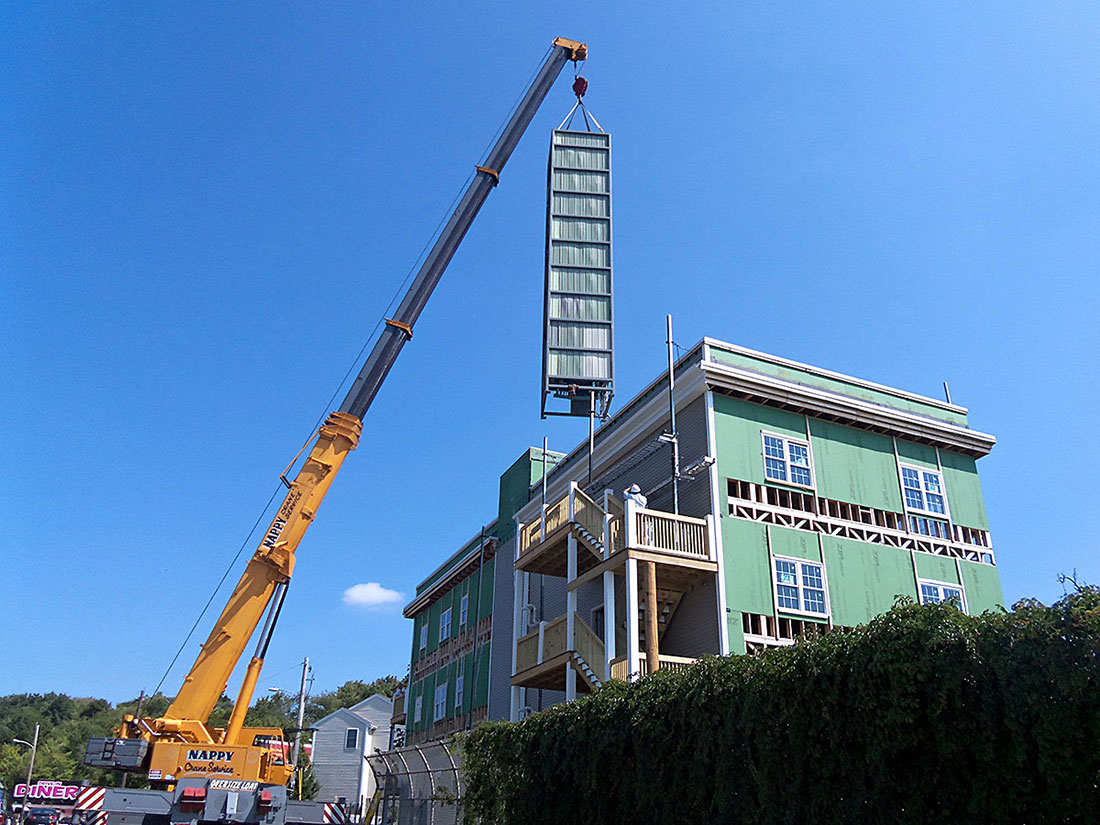 modular elevator on crane into apartment building